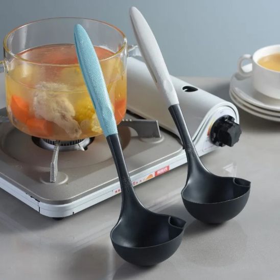 louche silicone bleue et louche silicone grise appuyées contre bocal de soupe