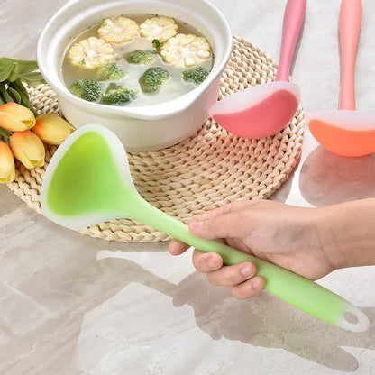 homme tient louche silicone verte à côté d'un bol de soupe