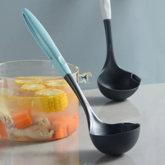 louche silicone avec manche bleu appuyée contre bol de soupe