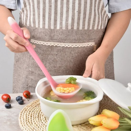 homme puise soupe dans une casserole à l'aide d'une louche
