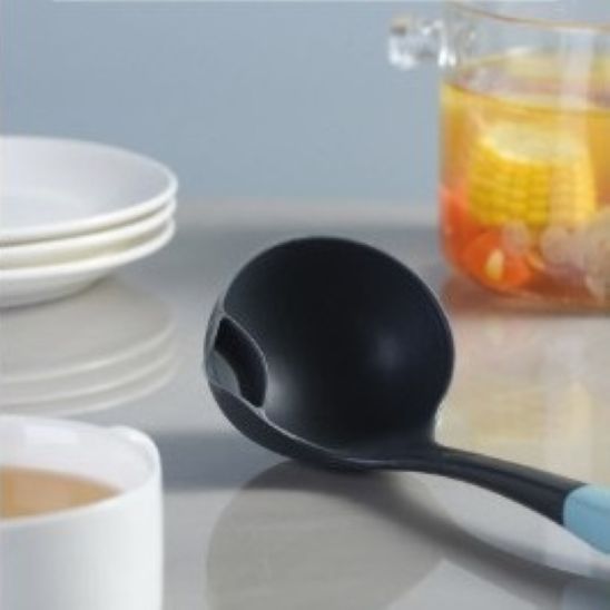 louche en silicone noir avec bec verseur sur comptoir cuisine
