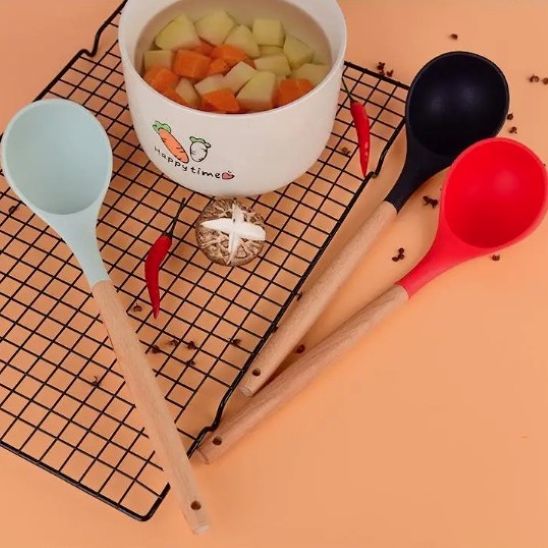 louche rouge, louche noir et louche menthe sur grille à côté d'un bol de soupe