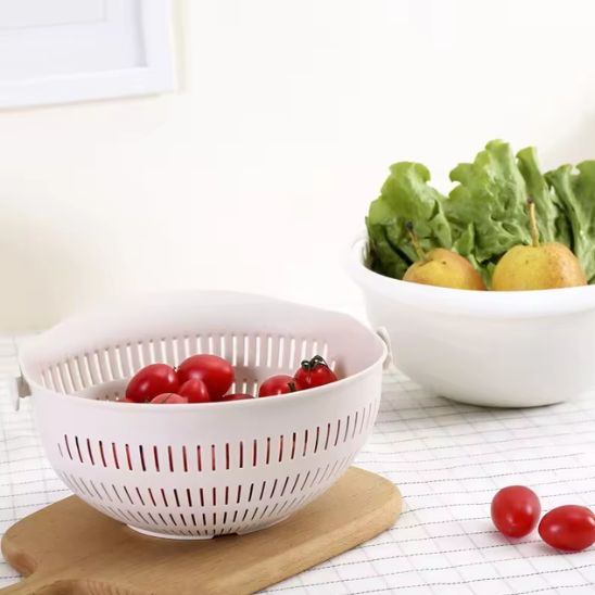 passoire-pivotatente-sur-une-planche-à-coté-du-basin-contenant-fruits-et-légumes