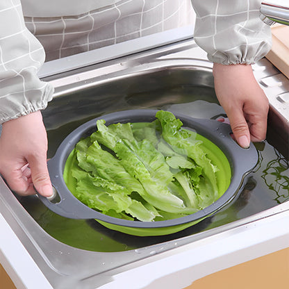 femme lave legumes dand passoire pliable