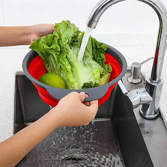 femme tient passoire pliable par poignees