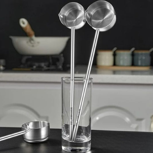 deux louches debout dans un verre et une  sur comptoir à côté