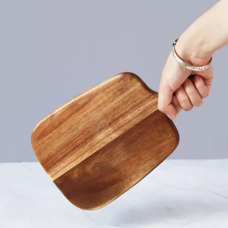 main-de-femme-tien-planche-a-decouper-carrée