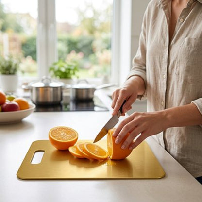 femme coupe orange sur planche a decouper dorée