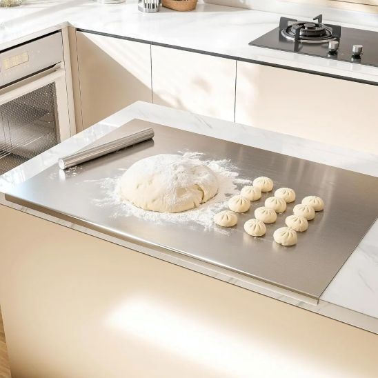 pâte et quenelles sur grande planche à découper en acier inoxydable