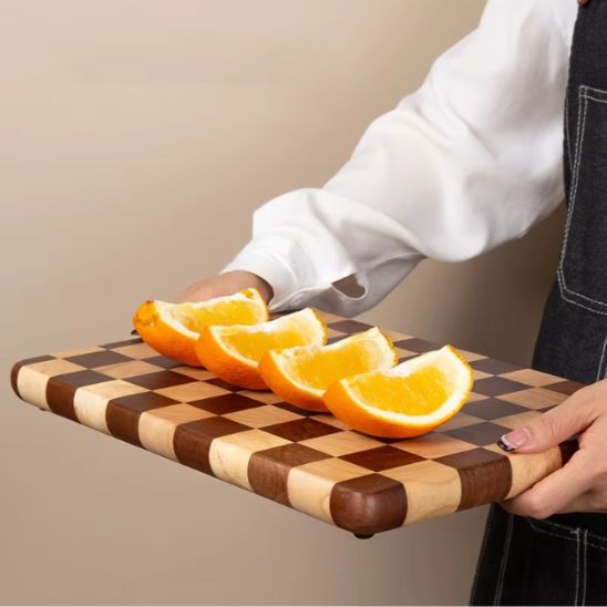 homme porte planche à découper damier avec oranges tranchées