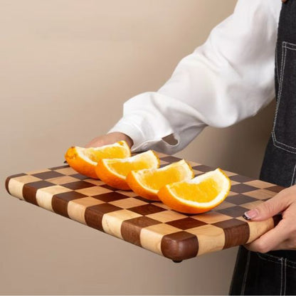 homme porte planche à découper damier avec oranges tranchées