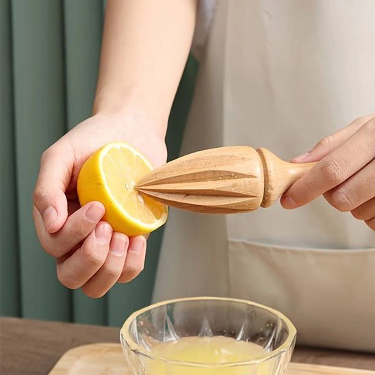 femme extrait jus citron avec presse agrumes en hêtre