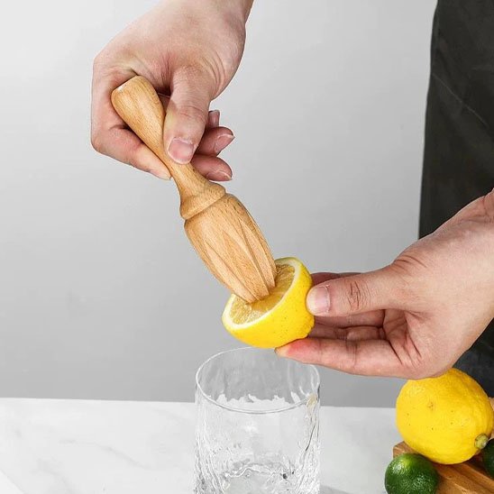 homme estrait jus citron avec presse agrumes en bois