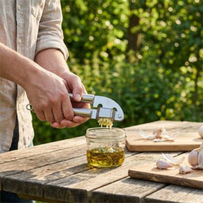 homme écrase ail dans vinaigrette avec presse ail sur table de picnic