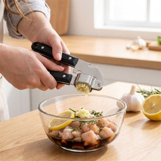cuisinière utilise presse ail pour écraser ail dans bol de poulet
