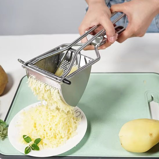 femme écrase pommes de terre dans assiette blanche utilisant presse purée