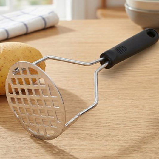 Presse-purée couché sur comptoir cuisine en bois
