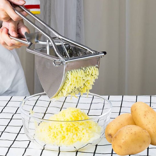 homme écrase pommes de terre dans bol en verre utilisant presse purée