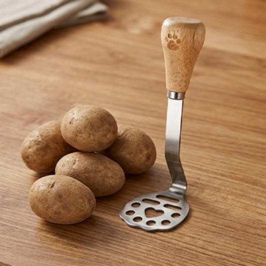 Presse purée miniature sur comptoir cuisine bois auprès de pommes de terre