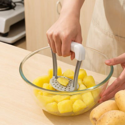 cuisinière écrase pommes de terre dans bol en verre utilisant presse purée