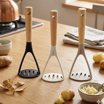 trois couleurs de presse-purée sur comptoir cuisine en bois