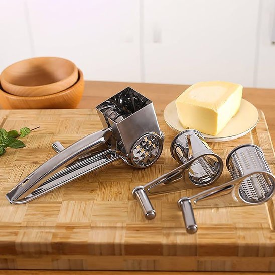 Râpe à fromage à manivelle avec trois cilyndres de râpage sur comptoir cuisine en bois