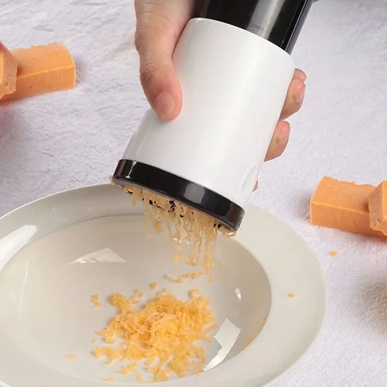 Cuisinier râpe fromage jaune dans bol  avec moulin râpe à fromage