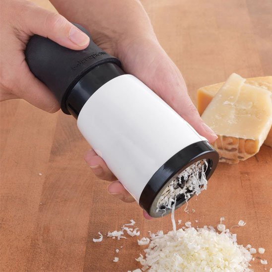 Cuisinier râpe parmesan sur comptoir en bois avec moulin râpe à fromage