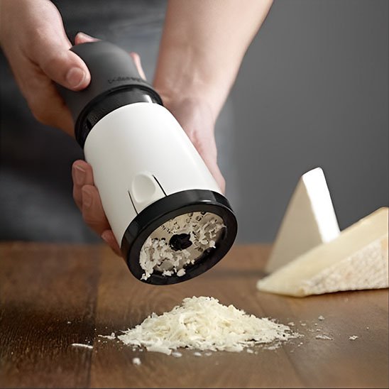 Cuisinier râpe fromage sur comptoir en bois avec moulin râpe à fromage 