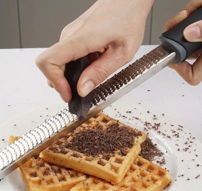 femme-rape-chocolat-finement-sur-gauffres-avec-rape-multiplane