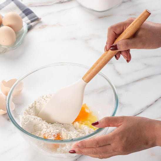 cuisinière mélange pâte avec spatule cuisine