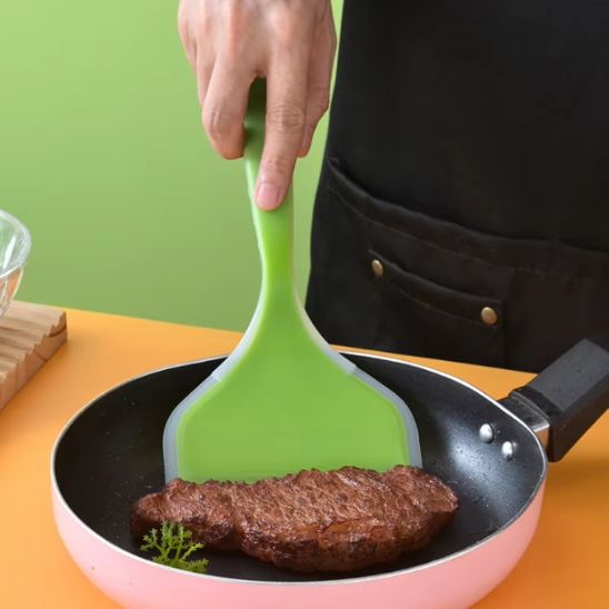 homme ramasse steak avec spatule large du poêle