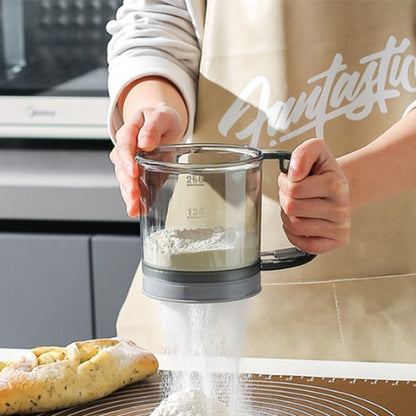 cuisinier-tamise-sucre-glace-avec-un-tamis-a-manivelle