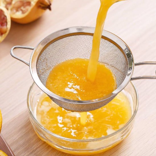 jus d'orange filtré dans verre avec petit tamis cuisine