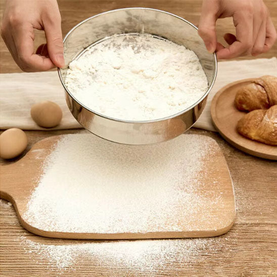 farine-tamisé-sur-plance-à-pétrissage avec-tamis-inox-rond