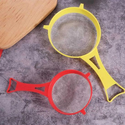 tamis rouge et tamis jaune en plastique sur comptoir gris