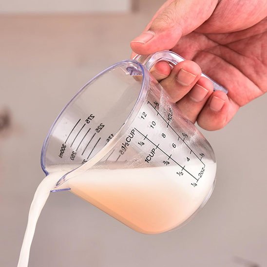 homme verse lait d'un verre doseur 