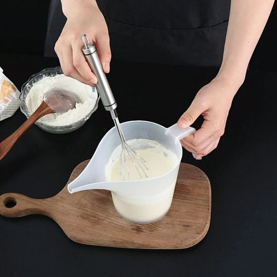 cuisinier fouette pâte dans verre doseur 