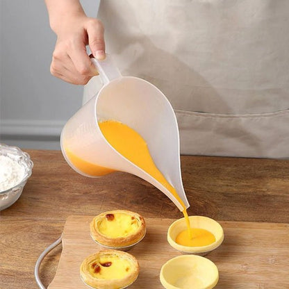 cuisinier verse crème anglaise du verre doseur dans tartelettes