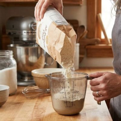 cuisinière verse farine dans verre doseur 