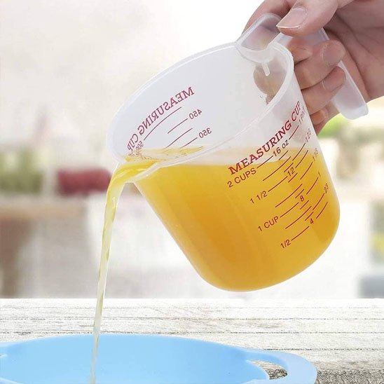 cuisinier verse bouillon dans bol du verre doseur 