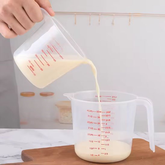 homme transverse lait d'un verre doseur à lautre