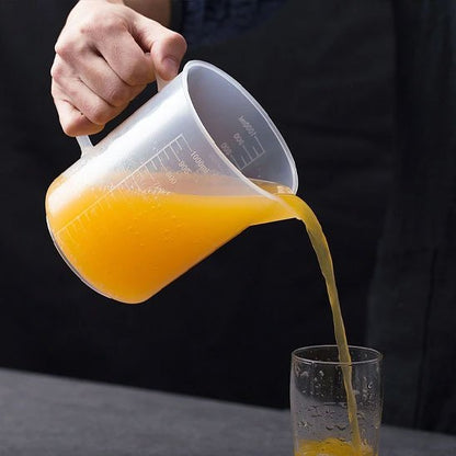 homme verse jus du verre mesureur dans un verre.